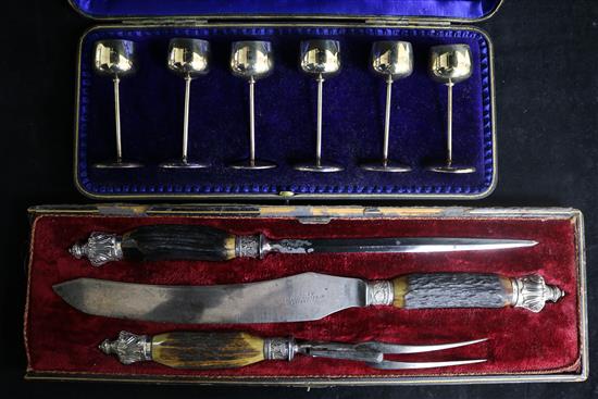 A set of six miniature silver-stemmed goblets and a three-piece carving set (both cased).